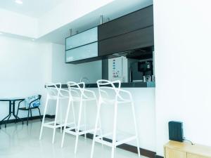 a kitchen with white stools and a black cabinet at Apt Platinum Rodadero 9C in Estación El Salto