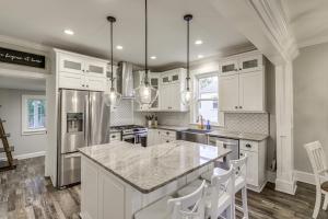 a kitchen with white cabinets and a large island at Modern Comfort Near Columbus Home with Yard and Porch in London