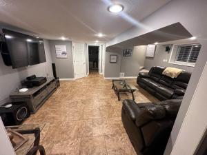 a living room with a couch and a tv at Executive Home in Timmins