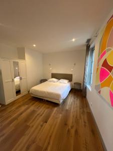 a bedroom with a bed and a wooden floor at La Maison des Filles in Agen +8 photos