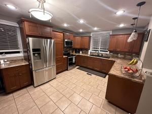 a kitchen with wooden cabinets and a stainless steel refrigerator at Executive Home in Timmins