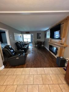 a living room with leather couches and a table at Executive Home in Timmins