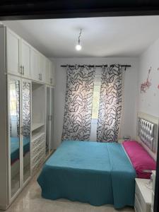a bedroom with a blue bed and a window at Appartement tangier airport in Hajreien +29 photos