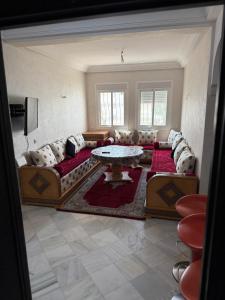 a living room with a couch and a table at Appartement tangier airport in Hajreien