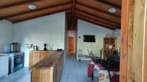 a large kitchen with wooden cabinets and a stove at Cabañas Mañio Melipeuco in Melipeuco +4 photos