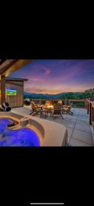 a jacuzzi tub on a balcony with a patio at Family Chalet With Rooftop Theater GameRoom Mins to DT in Gatlinburg