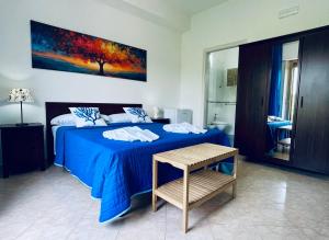 a bedroom with a blue bed and a table at La Gorgonia in Trapani