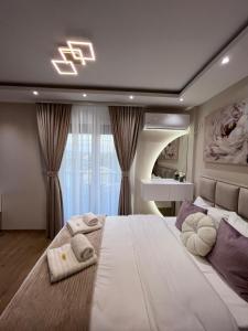 une chambre avec un grand lit avec des serviettes dessus dans l'établissement Apartman NIKOLINA, à Vrnjačka Banja 36 autres photos