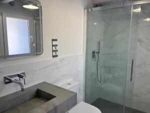 a bathroom with a shower and a toilet and a sink at Apartamentos Catamarán Azul in Suances