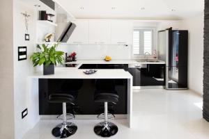 eine Küche mit einer weißen Theke und schwarzen Geräten in der Unterkunft Dream Apartment in Podstrana