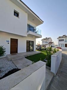 Casa blanca con balcón y patio en Nadine sea side villas, en Lárnaca