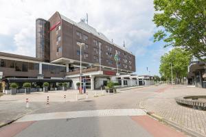 an empty street in front of a building at Leonardo Hotel Lelystad City Center in Lelystad