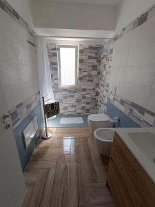 a bathroom with two toilets and a tub and a sink at Solleone - Appartamento 2B in Paestum