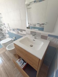 a bathroom with a sink and a toilet at Solleone - Appartamento 2B in Paestum +17 photos