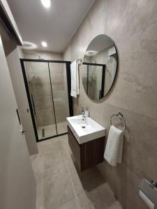 un bagno con lavandino e specchio di Nadine sea side villas a Larnaka