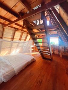 una cama en una habitación con suelo de madera en Origen Zelvamar, en Bahía Solano