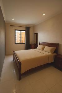 un dormitorio con una cama y una ventana en Bel appartement avec une belle vue sur la grande mosquée Hassan II et la mer, en Casablanca