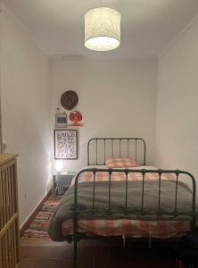 una camera da letto con un letto e un lampadario di A cozy cottage in Tomar a Tomar