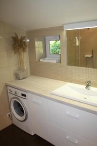 a bathroom with a sink and a washing machine at S11 in Palanga