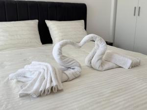 two towels shaped like swans sitting on a bed at Timo Apartments in Bragadiru