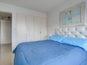 una camera da letto con un letto con un piumone blu di Piso 14, Espectaular! a Punta del Este
