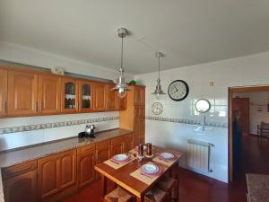a kitchen with a table and a clock on the wall at Recanto da Tia in Póvoa de Santa Iria