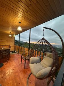 Zimmer mit einem Schaukelstuhl auf dem Balkon in der Unterkunft chemi kera chalet 2 in Angisa