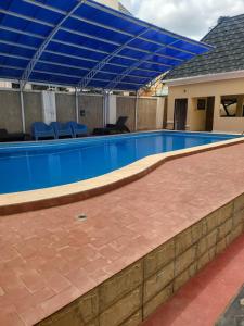 a swimming pool with a blue canopy over it at The Perfect Place in Gwarinpa +2 photos