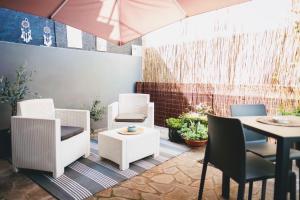 a patio with white chairs and a table and a table at Suite 31 in Rovigo