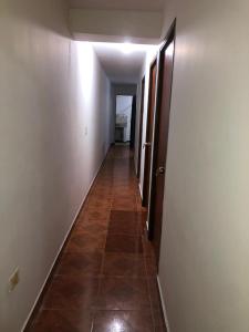 a hallway with a long hallway with a tile floor at Apartamento funcional cerca a Parque de Bello Antioquia in Bello
