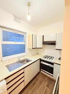 a kitchen with a sink and a stove at Spacious Room with Double and semi double bed, Shared bathroom,10 minutes to Aldgate East station, near Central London, for 4 ppl in London