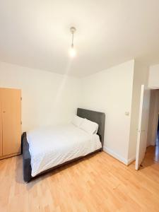 a bedroom with a bed with a light on the ceiling at Spacious Room with Double and semi double bed, Shared bathroom,10 minutes to Aldgate East station, near Central London, for 4 ppl in London