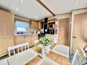 eine Küche und ein Esszimmer mit Tisch und Stühlen in der Unterkunft The Windermere- Luxury Caravan Retreat by the Sea in Devon in Burgh Island