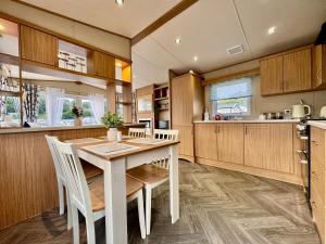 eine Küche mit einem Tisch und Stühlen in einer Küche in der Unterkunft The Windermere- Luxury Caravan Retreat by the Sea in Devon in Burgh Island + 26 Fotos
