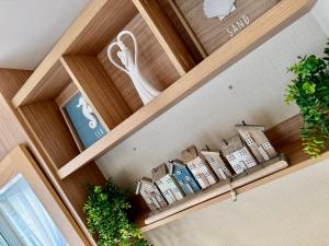 ein Haufen Kisten auf einem Regal mit Pflanzen in der Unterkunft The Windermere- Luxury Caravan Retreat by the Sea in Devon in Burgh Island