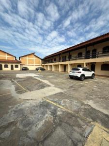 ein Auto, das auf einem Parkplatz vor einem Gebäude geparkt ist in der Unterkunft APT PERÓ Livio Viviani in Cabo Frio