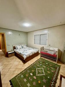 una camera con letto e tappeto verde di Harhoura, plage, piscine et confortable a El Harhoura