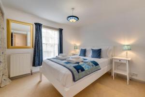 a bedroom with a large white bed and a window at Scribblers Cottage in Woodbridge