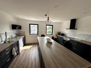 a large kitchen with a wooden table in it at Railway House, Halfway in Ballinhassig