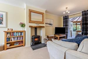 a living room with a couch and a fireplace at 1 Street Farm Cottages in Bodham