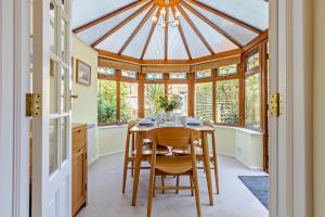 a kitchen with a table and chairs and a glass ceiling at 1 Street Farm Cottages in Bodham