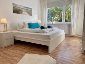 a white bed in a room with two windows at Haus-Jenina-Ferienwohnung in Cuxhaven