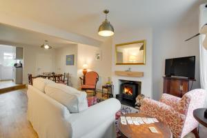 a living room with a white couch and a fireplace at Brook Cottage in Dersingham