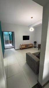 a living room with a television and a couch at Casa 650m da Orla da Atalaia in Aracaju