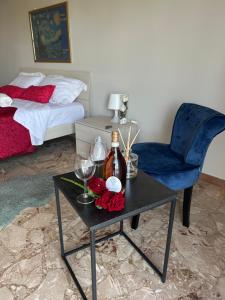 a room with a table with a bottle of wine and a chair at Marianna Guest House in Bracciano