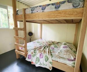 a bunk bed with a flowery comforter on it at Hostal La Sinarena in Buenaventura