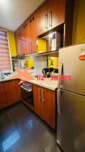 a kitchen with wooden cabinets and a stainless steel refrigerator at MODERNO TURISTICO Y EJECUTIVo in Santiago