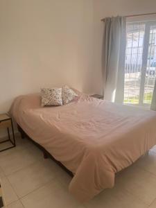 ein Bett mit zwei Kissen darauf in einem Schlafzimmer in der Unterkunft Depto Salta al Mar 2 in Puerto Madryn