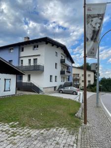 a white building with a car parked in front of it at Palazzina Rosa in Spormaggiore