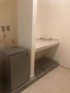 a room with a shelf and a small refrigerator at Departamento Familiar in Tampico